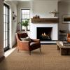 Everly Wool color Cognac in a living room.  Brown leather couches, white walls and brown wool rug