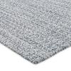 A close-up of a textured custom sisal rug surface covered with small, irregularly shaped black and white spots, resembling a speckled or dappled pattern.