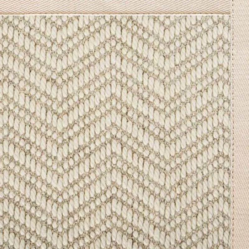 A close-up of a woven fabric with a chevron pattern in beige and light brown tones, bordered by a solid light beige edge—perfect inspiration for discount sisal rugs or sisal rugs on sale.