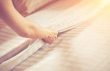 woman changing sheets in a guest bedroom