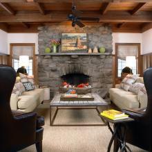 Modern Rustic Room with Stone Fireplace and Exposed Wooden Beams.